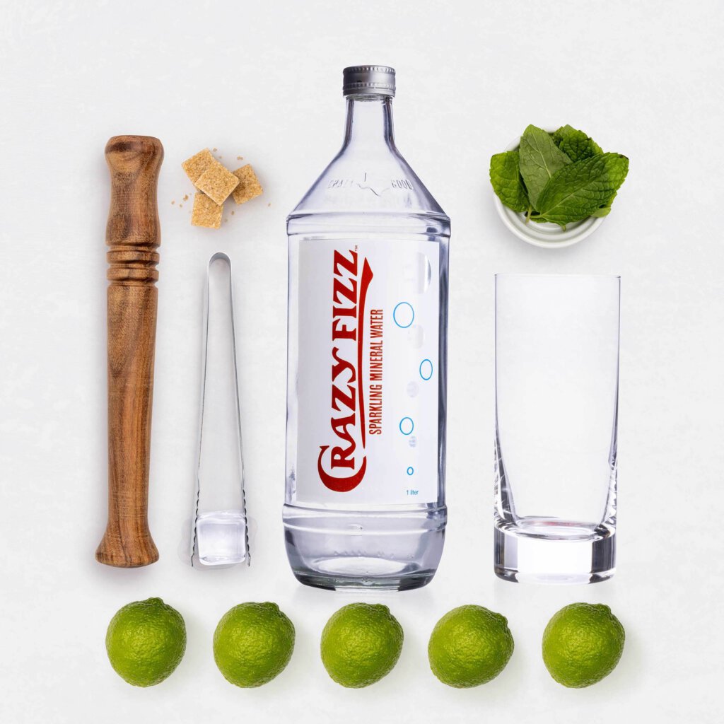 Crazy Water: Bottle of Crazy Fizz Sparkling Mineral Water with muddler, mint, sugar and limes